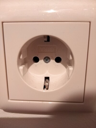 Weiße Schuko-Wandsteckdose mit zwei runden Löchern.