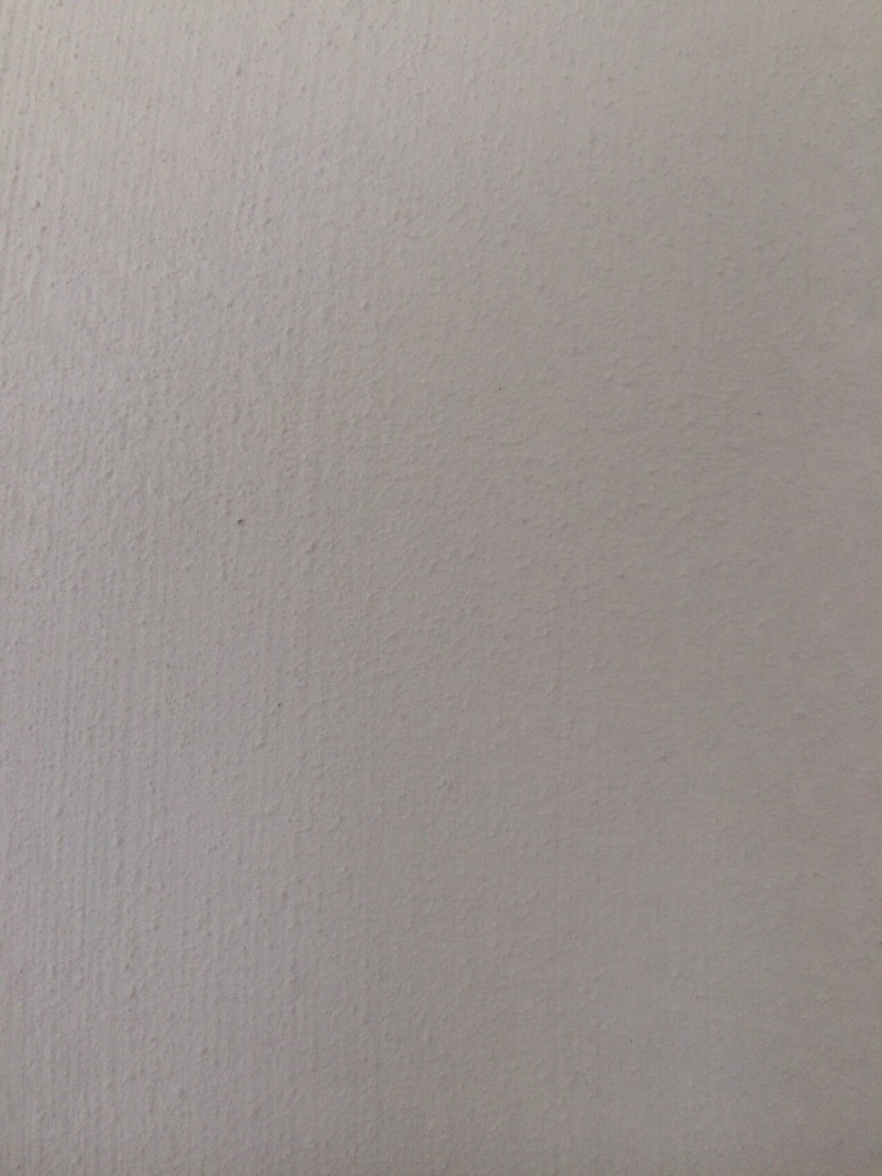 Nahaufnahme einer weißen, strukturierten Wandoberfläche aus Putz.