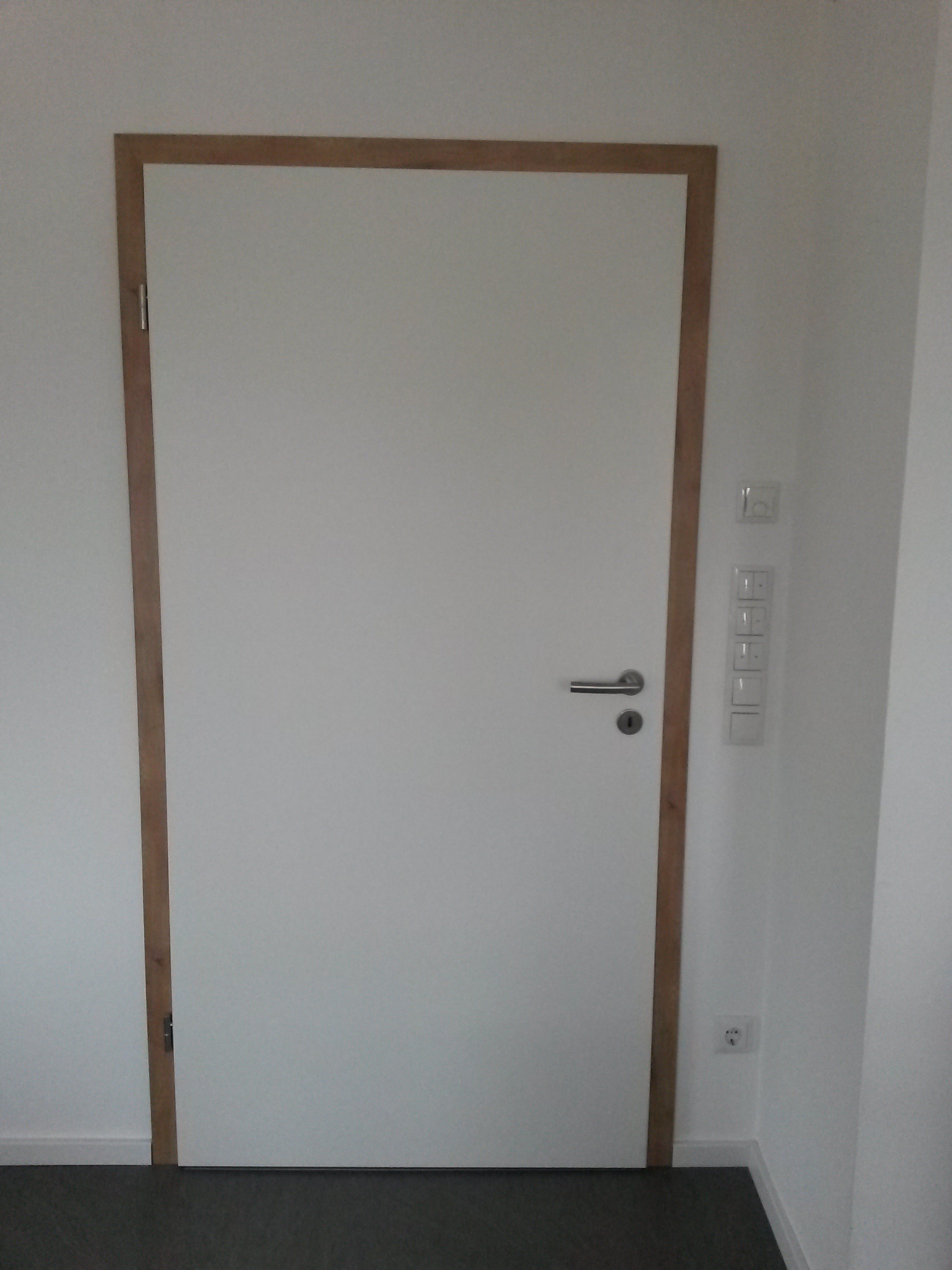 weisse-tuer-mit-holzrahmen-im-flur.jpg