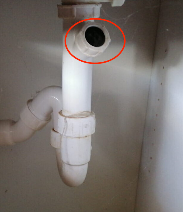Unter der Spüle offenes Rohrende über dem Siphon, P-Trap sichtbar