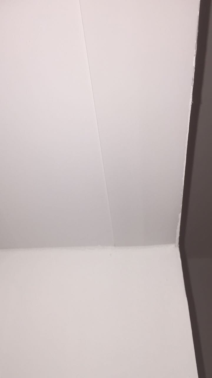 Weisse Wand- und Deckenfläche mit sichtbarer Fuge im Innenraum