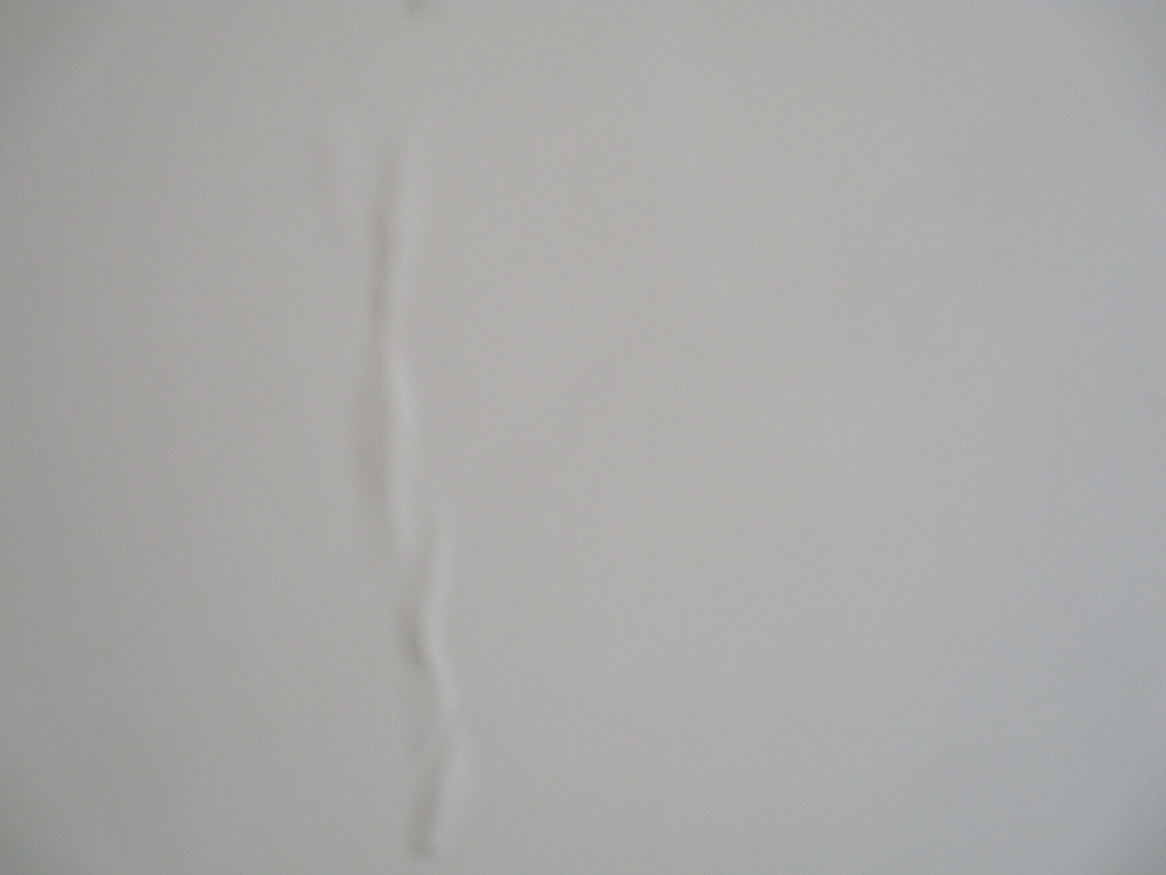 Weißes Blatt Papier mit einer senkrechten Falte in der Mitte.