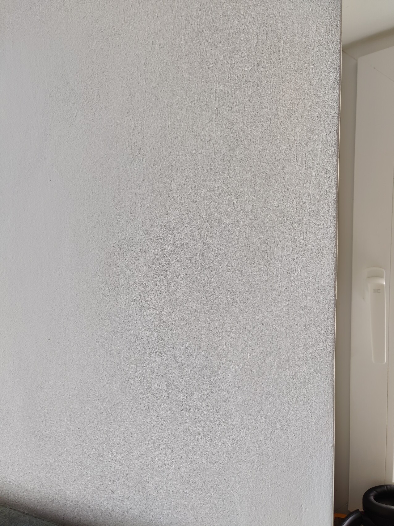 Weiße Wand mit feiner Struktur; rechter Rand zeigt Tür-/Schrankkante.