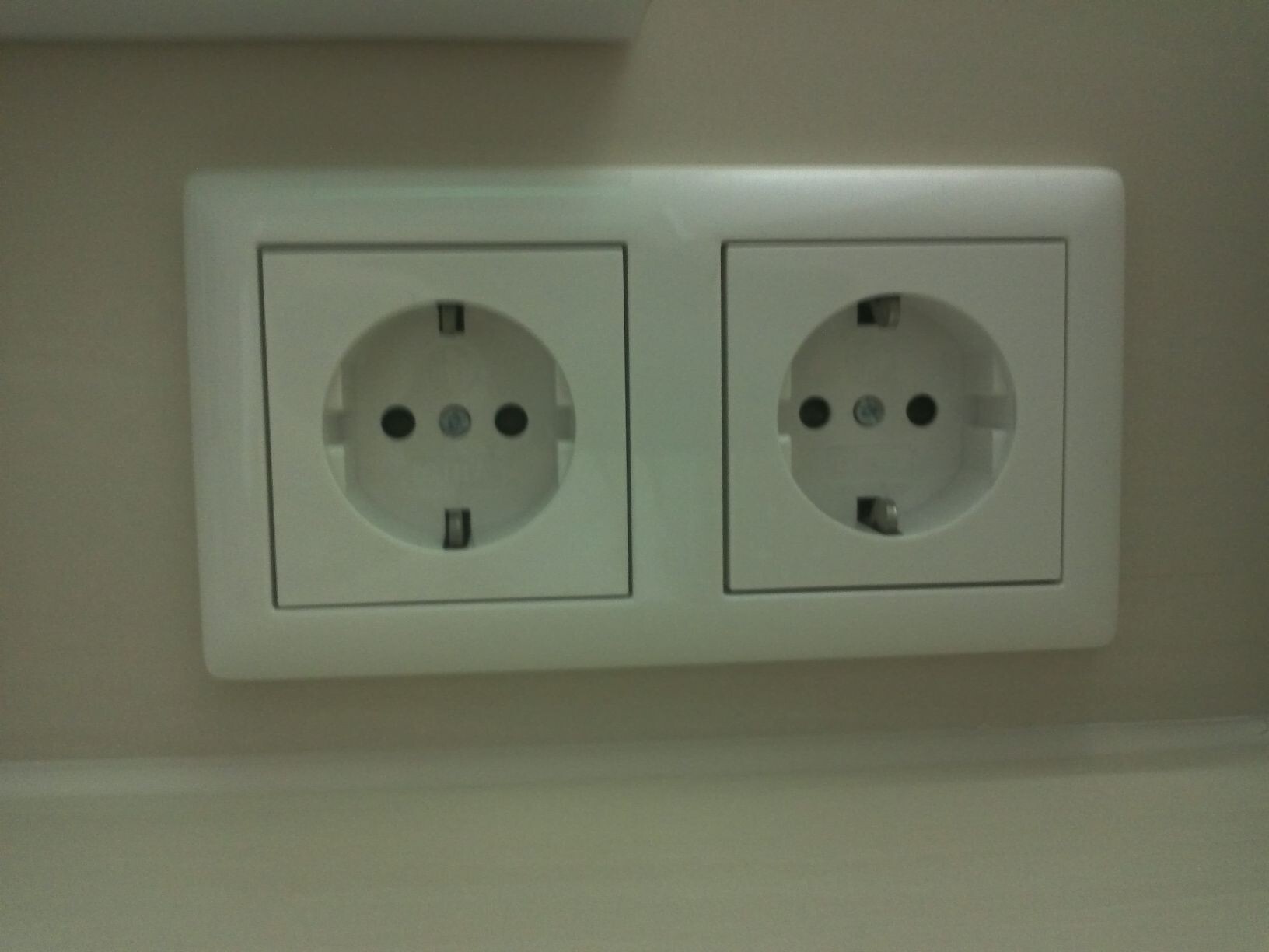 Zwei weiße Schuko-Steckdosen nebeneinander in einer Wandplatte.