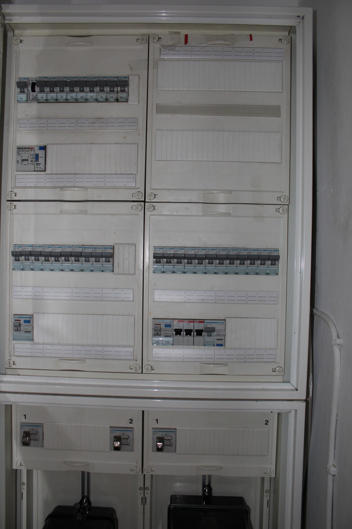 Elektrischer Verteilerkasten mit vielen Sicherungsautomaten in zwei Spalten.