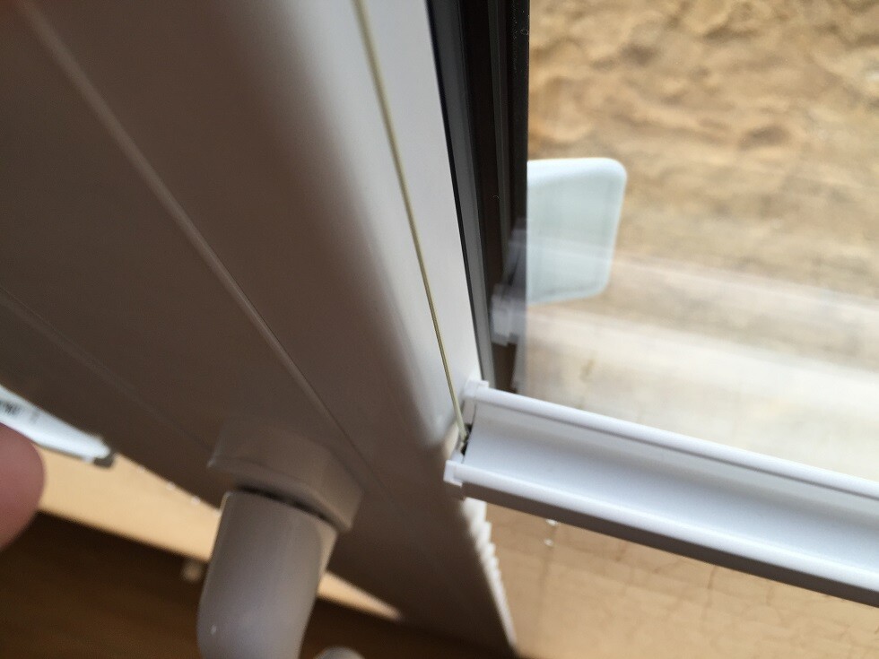 Nahaufnahme eines weißen Kunststofffensterrahmens mit Dichtung und Glas