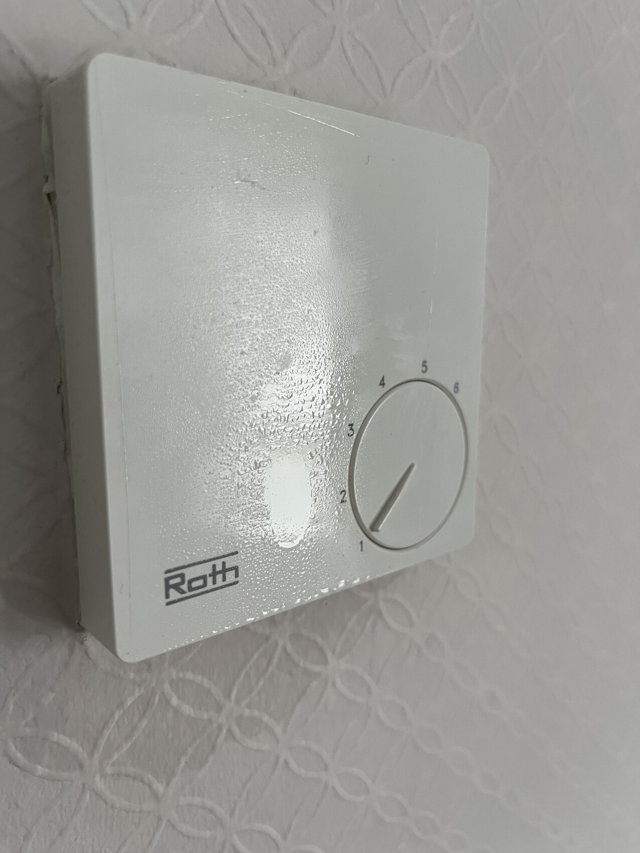 Weißer Wandthermostat mit Rundknopf, Skala 1–6, Roth-Logo