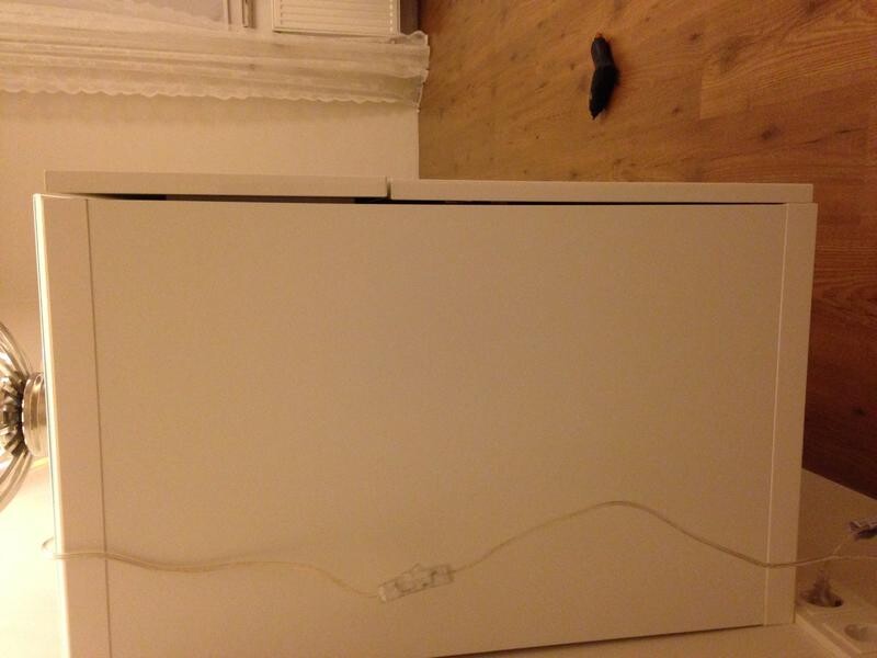 Weisser schrank auf holzboden, kabel liegt ueber der front, renovierungsarbeiten sichtbar