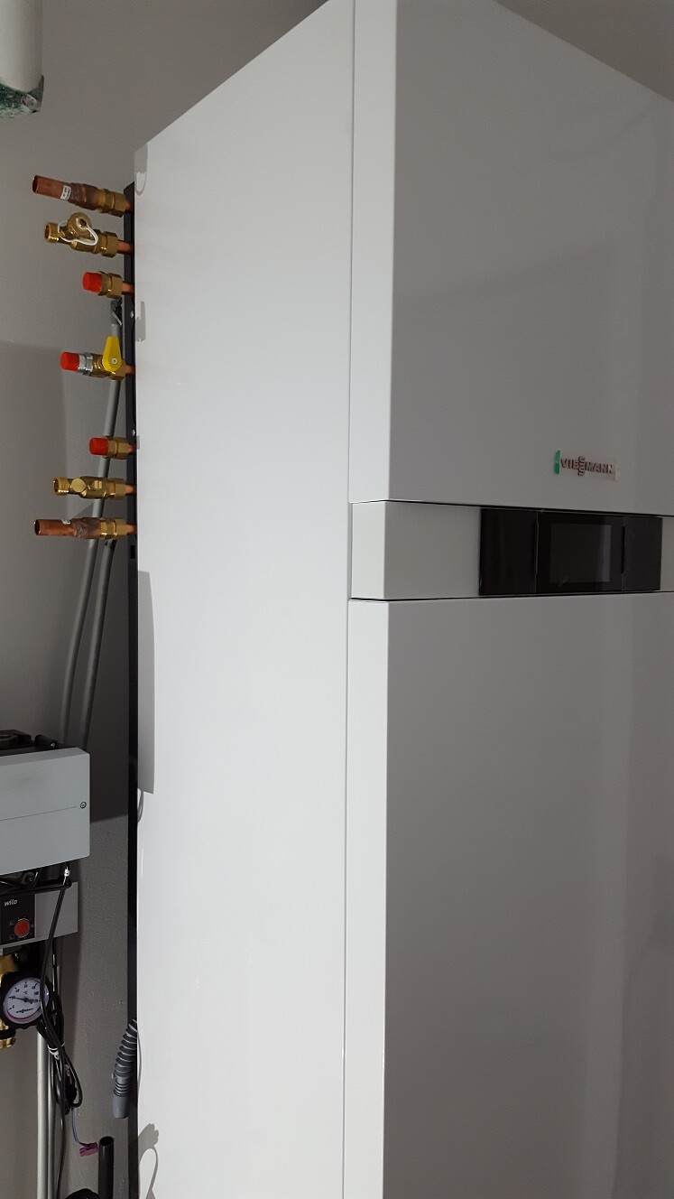 Weiße Viessmann-Heizungsanlage mit seitlich sichtbaren Kupferrohren.