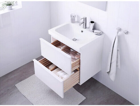 Weißes Waschbecken mit offenen Schubladen, Handtuchhalter und moderner Armatur.