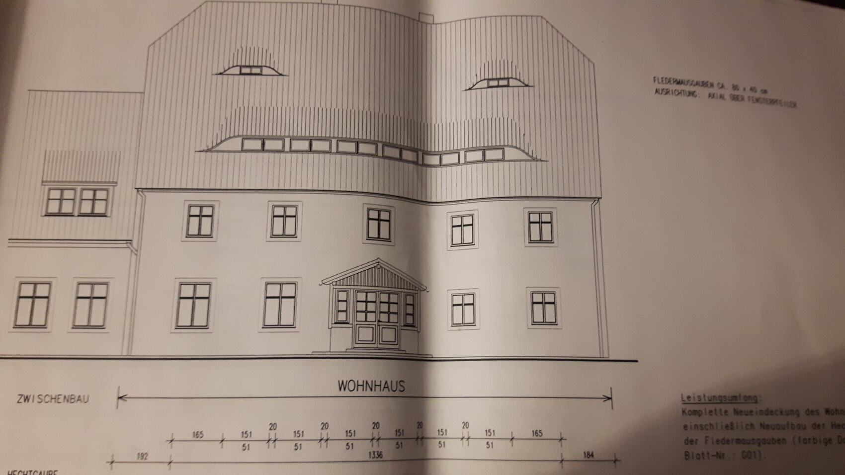 Architektenzeichnung eines mehrstöckigen Wohnhauses mit Dachgauben.