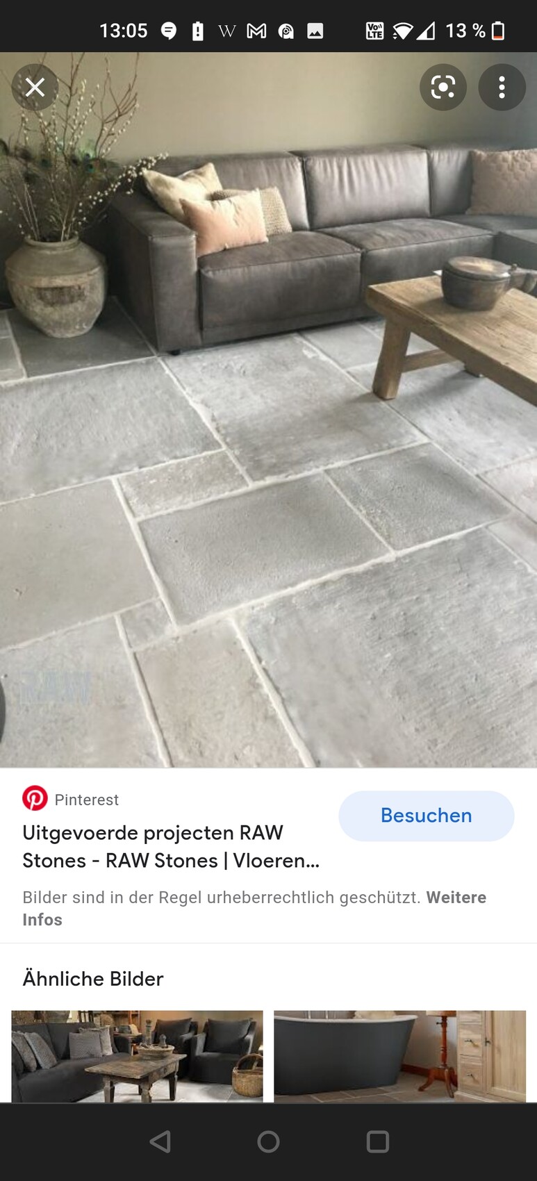 Rustikales Wohnzimmer mit grauem Sofa und Steinboden aus großen Fliesen