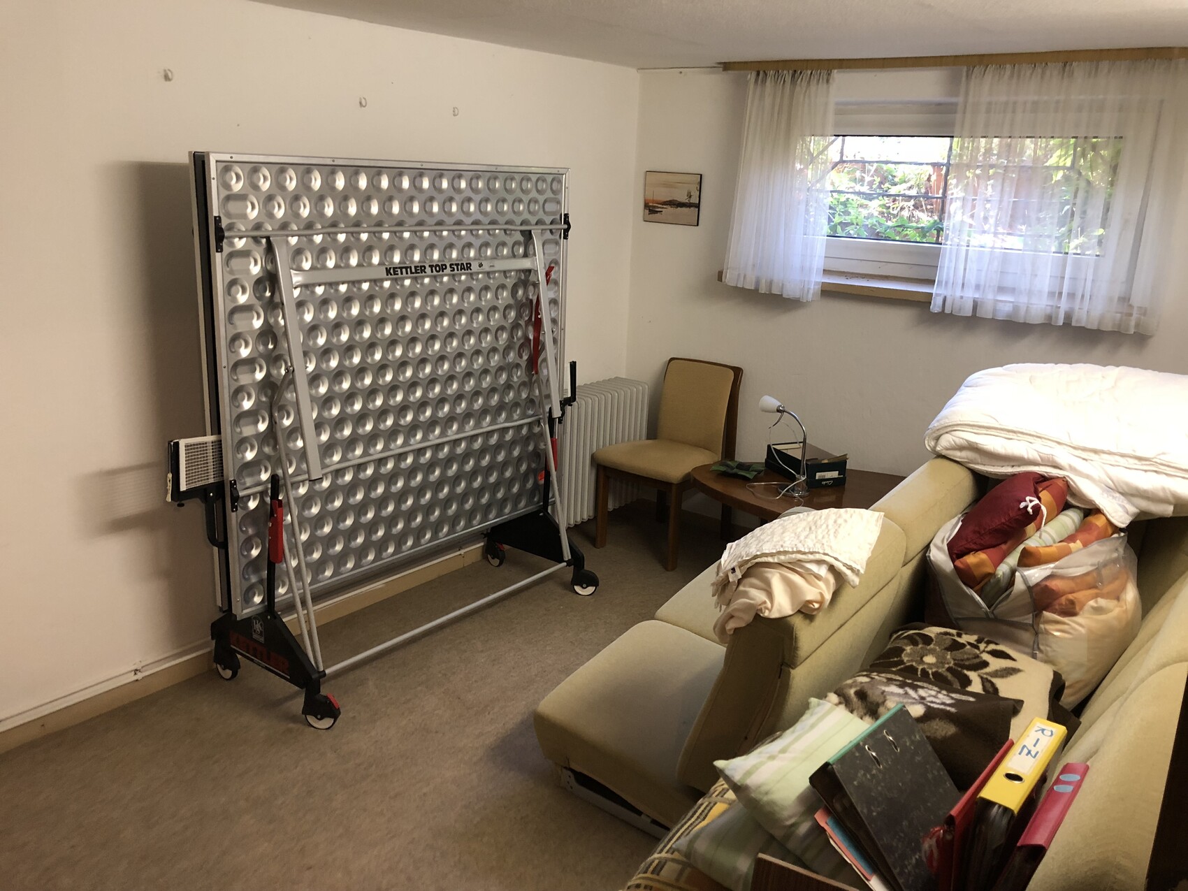Großes Metallgerät Kettler Top Star mit runden Vertiefungen steht an der Wand im Wohnzimmer.