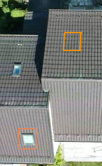 Vogelperspektive auf Flachdächer; zwei orange Markierungen markieren Bereiche auf Dach und Wand.